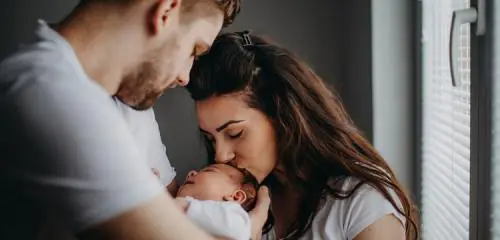 Kobieta i mężczyzna przytulają małe dziecko