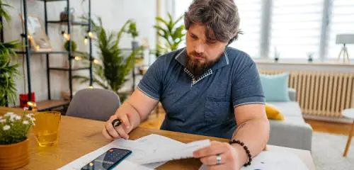 Mężczyzna sprawdza stan swoich finansów - liczy rachunki