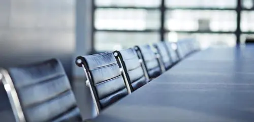 czarne skórzane fotele ustawione wzdłuż stołu konferencyjnego