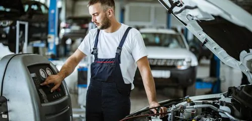 Mechanik nabijający klimatyzację w warsztacie samochodowym