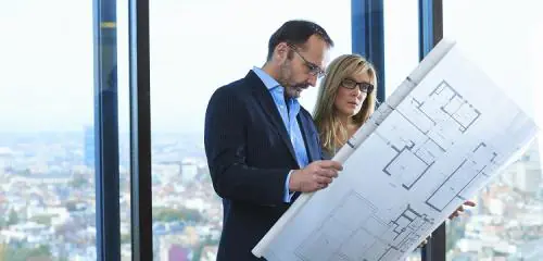 Architekci patrzą na plany budowy nieruchomości