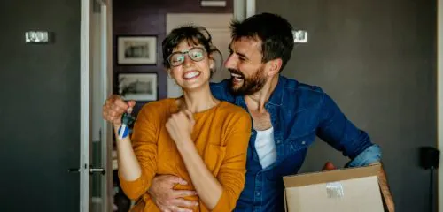 Kobieta i mężczyzna wprowadzają sie do mieszkania, które kupili na kredyt