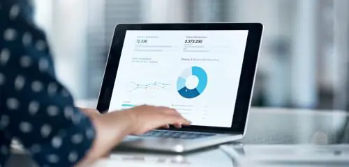 kobieta obliczające na laptopie poziom kosztu kapitału własnego