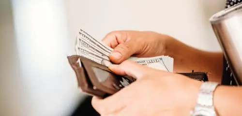 Kobieta liczy pieniądze wypłacone z konta Revolut