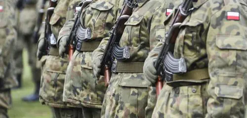 Widok kilku żołnierzy z karabinami przy mundurach