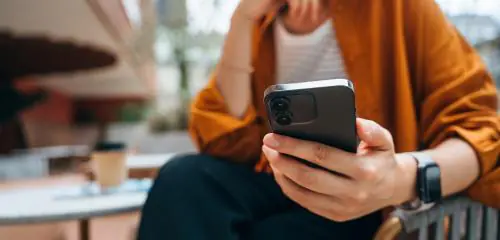 Kobieta trzyma w dłoni telefon komórkowy