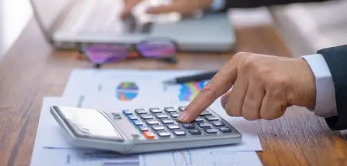 mężczyzna sprawdzający na kalkulatorze, jaki jest najkorzystniejszy kredyt hipoteczny na 2 mln zł
