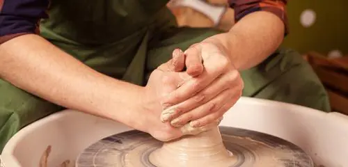 Osoba pracująca na kole garncarskim wytwarzająca ceramikę