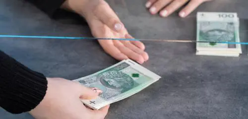 Mężczyzna wpłaca pieniądze w kasie banku