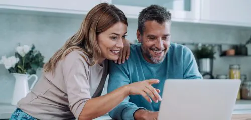 Zadowolona para sprawdzająca na laptopie najlepsze lokaty bankowe na 6 miesięcy w rankingu online