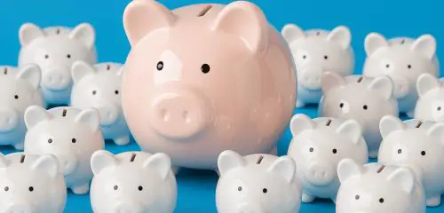 świnki skarbonki na niebieskim tle. W środku większa różowa świnka skarbonka. Pozostałe w kolorze białym.