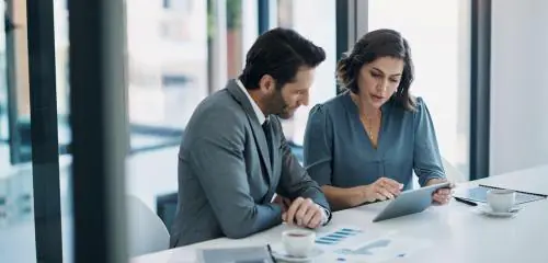 doradczyni finansowa podczas spotkania z klientem, pokazuje jak pomnożyć oszczędności i sięgnąć po wysoki zysk