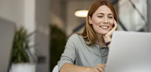 Zadowolona kobieta na laptopie zakłada lokatę na 3 miesiące online