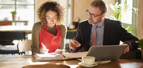 Kobieta pokazuje doradcy kredytowemu dokumenty potrzebne do uzyskania kredytu na B2B