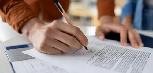Mężczyzna podpisuje druk wycofania zgody na przetwarzanie danych BIK w PKO