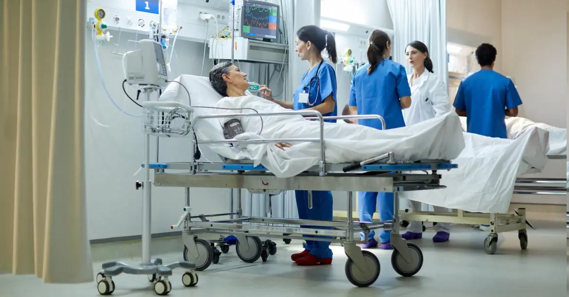 osoba leżąca na łóżku w szpitalu i personel medyczny obok