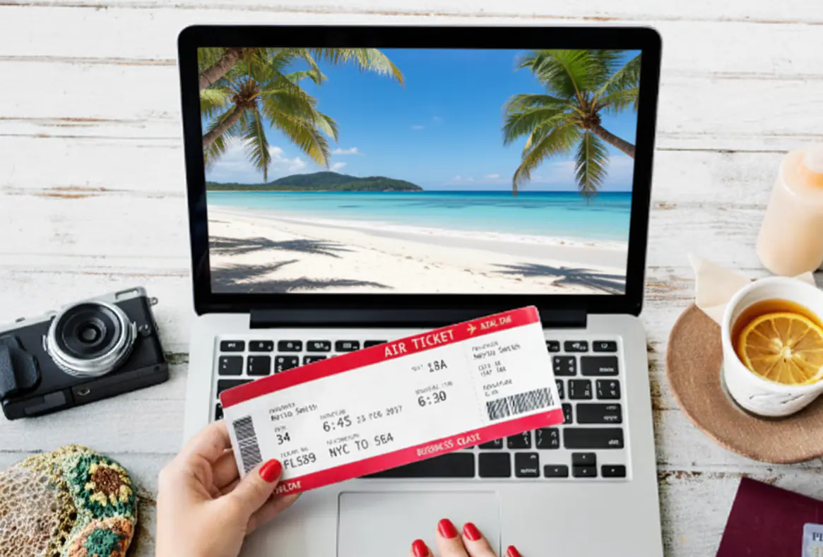 dłonie kobiety trzymające bilet podróżny na tle laptopa
