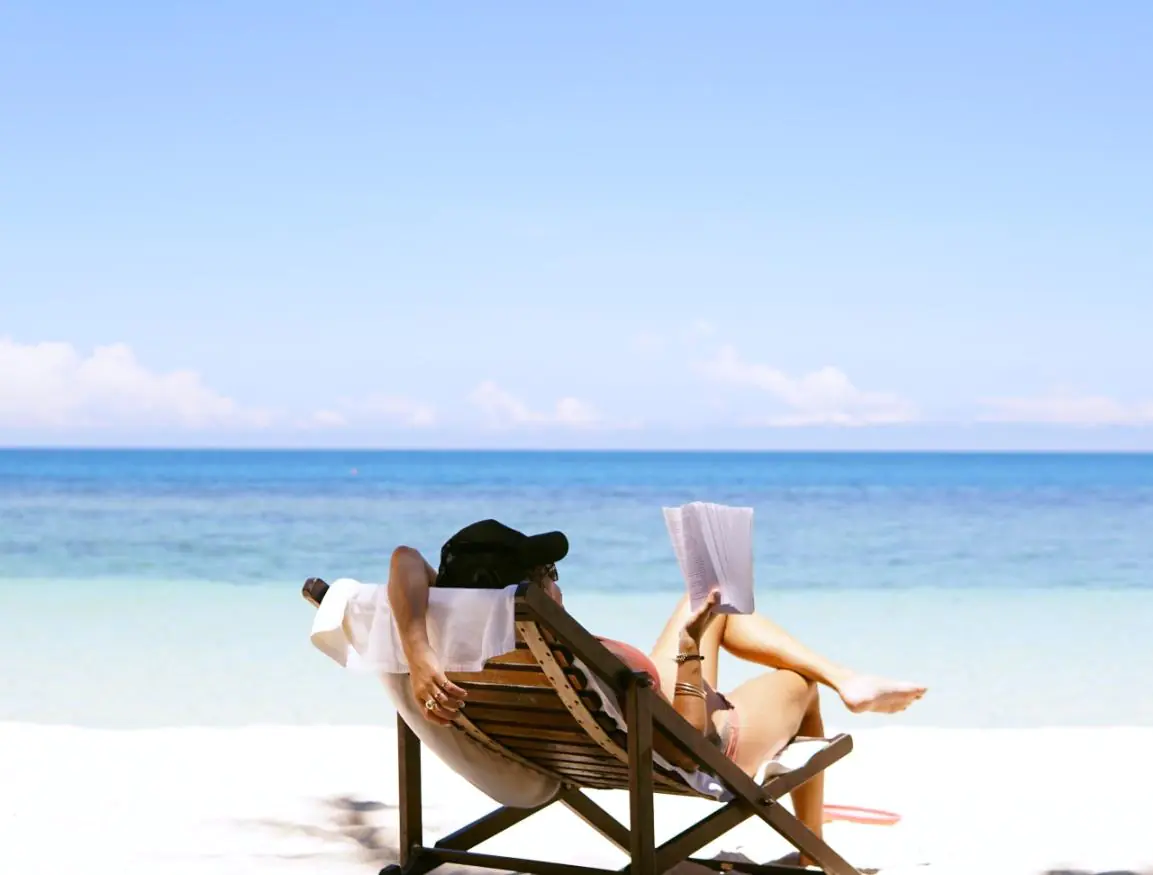 Kobieta czytająca na plaży, na leżaku