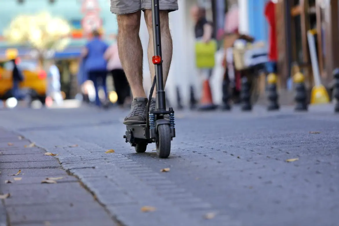 Osoba jadąca hulajnogą elektryczną