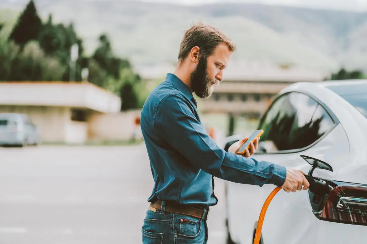 Mężczyzna ładuje samochód elektryczny