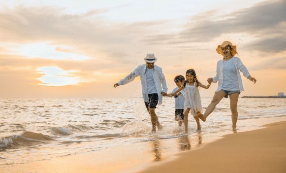 Rodzina na plaży o zachodzie słońca