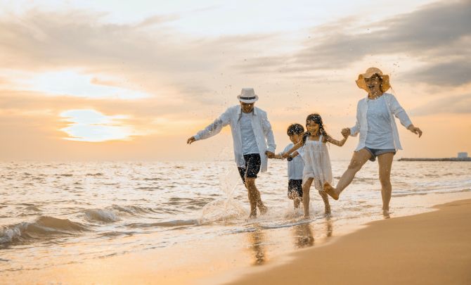 Rodzina na plaży o zachodzie słońca