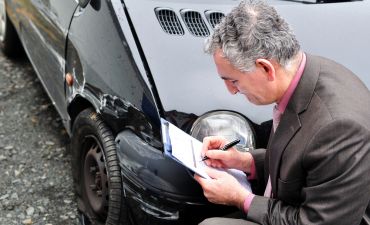 Rzeczoznawca ogląda uszkodzony samochód