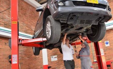 mechanicy naprawiający samochód