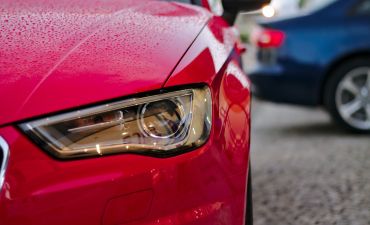 reflektor czerwonego samochodu, który ma wykupione OC na miesiąc