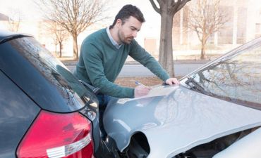 Mężczyzna spisuje oświadczenie po stłuczce