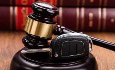 młotek sędziowski i kluczyk do samochodu na tle kodeksów