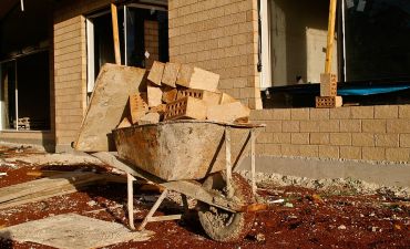 taczka z cegłami na placu budowy domu