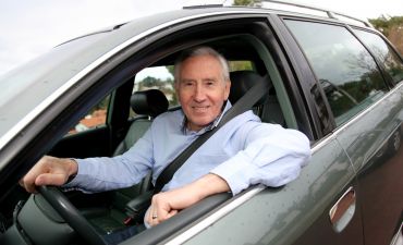Zadowolony senior, który ma wykupione dobre ubezpieczenie oc samochodu