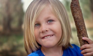 Dziecko, które jest zadowolone bo rodzice mu wykupili prywatne ubezpieczenie zdrowotne