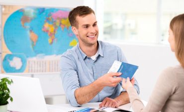 mężczyzna przegląda oferty w biurze podróży TUI