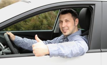 mężczyzna zadowolony w samochodzie bo posiada Minicasco