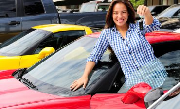 Młoda kobieta zadowolona z zakupu samochodu