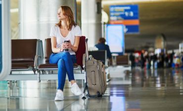 kobieta na lotnisku z bagażami w tle