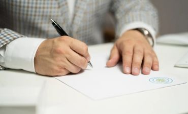 mężczyzna podpisuje umowę