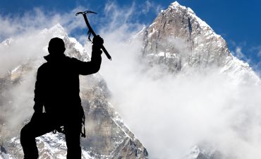 himalaista na tle górskiego szczytu