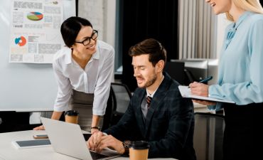 pracownicy w biurze pijący kawę i rozmawiający