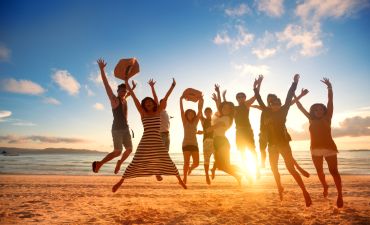 młodzi ludzie na wakacjach skaczący w górę