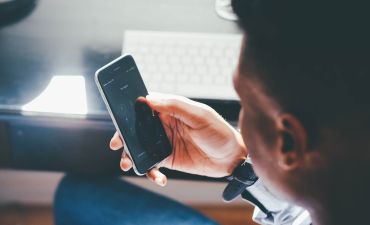 mężczyzna trzyma w ręku telefon