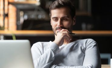 młody mężczyzna patrzy się w ekran laptopa