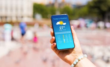 telefon z aplikacją pogodową trzymany w ręku