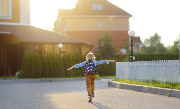 chłopiec biegnący po ulicy w strefie zamieszkania