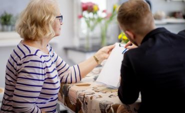 Kobieta uzupełnia wniosek o rejestrację pojazdu