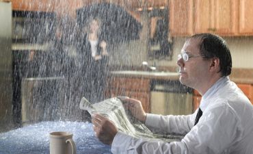 para ludzi w kuchni zalewanej przez deszcz