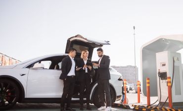 trójka ludzi analizująca dane techniczne Tesli model X