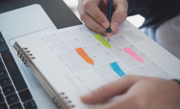 człowiek zapisujący notatki w kalendarzu